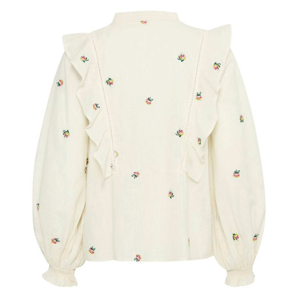 Cream floral-embroidered blouse with ruffle details, long sleeves, and a small collar.