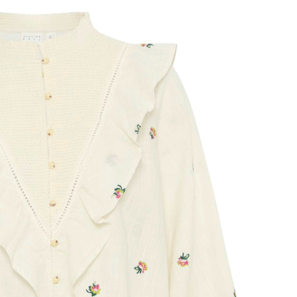 Atelier Reve Birch Olivia Blouse, cream-colored floral-embroidered design with ruffles and long sleeves.