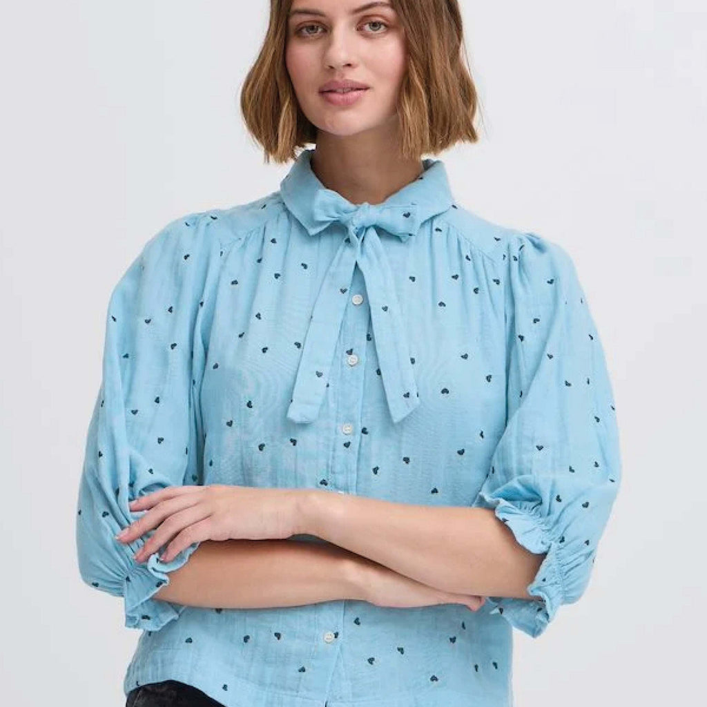 Pale blue heart-embroidered blouse with pan collar and tie by Atelier Reve.