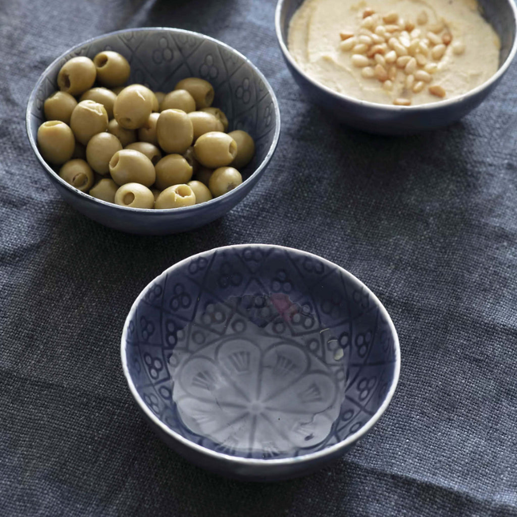 Blue Fiskardo Nibble Bowl with olives and hummus on dark tablecloth.