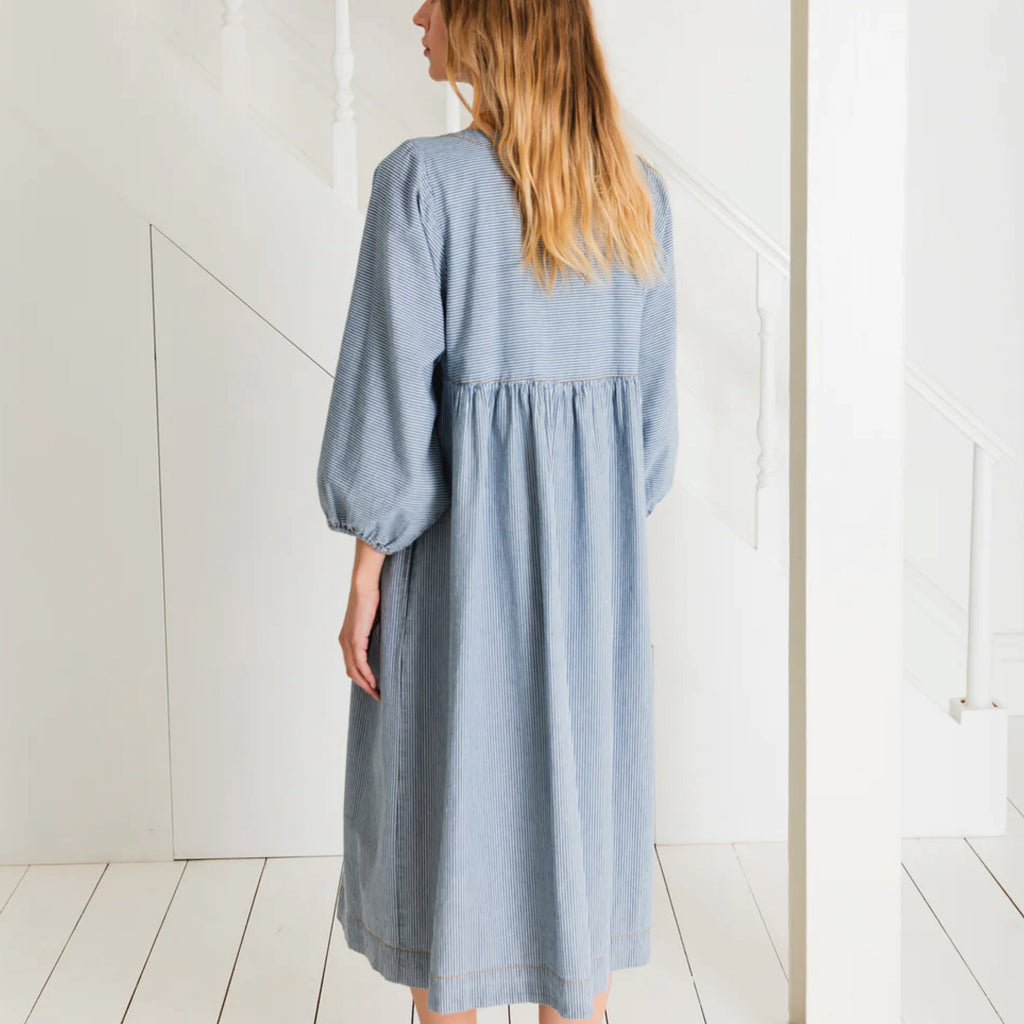 Relaxed easy-fit organic self stripe blue cotton dress with a bow fastening detail and an empire line.
Bonté Blue Amber Dress - Jo And Co Bonté Blue Amber Dress - Bonté