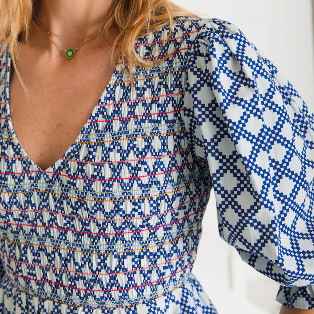 A tiered, smocked bodice dress in a geometric organic cotton poplin print with v-neck.
Bonté Blue & White Troy Dress - Jo And Co Bonté Blue & White Troy Dress - Bonté