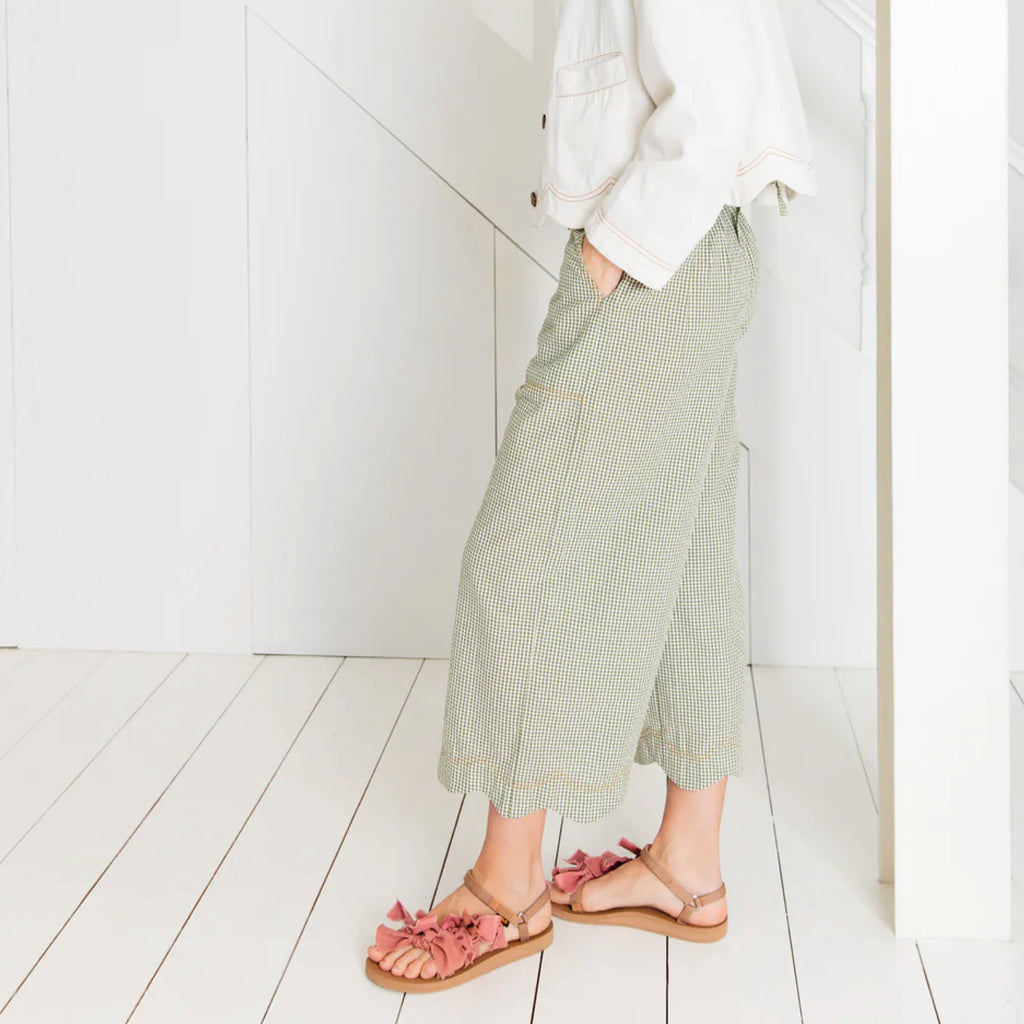 Relaxed fitting three-quarter length wide leg trouser in green cotton seersucker gingham with an elasticated back and scallop hem.
Bonté Green Gingham Aide Trousers - Jo And Co Bonté Green Gingham Aide Trousers - Bonté