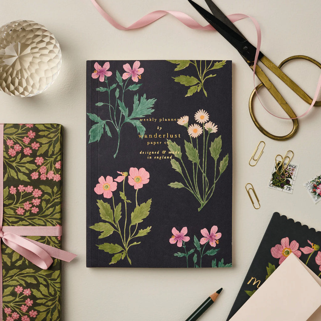 Botanical Weekly Planner with floral design by Wanderlust Paper Co, lay-flat binding.