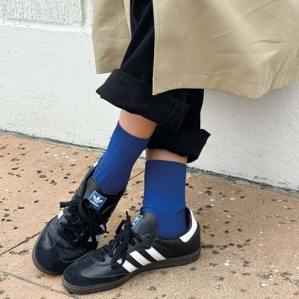 Le Bon Shoppe Cobalt Her Socks in blue, ribbed knit, worn with black sneakers.