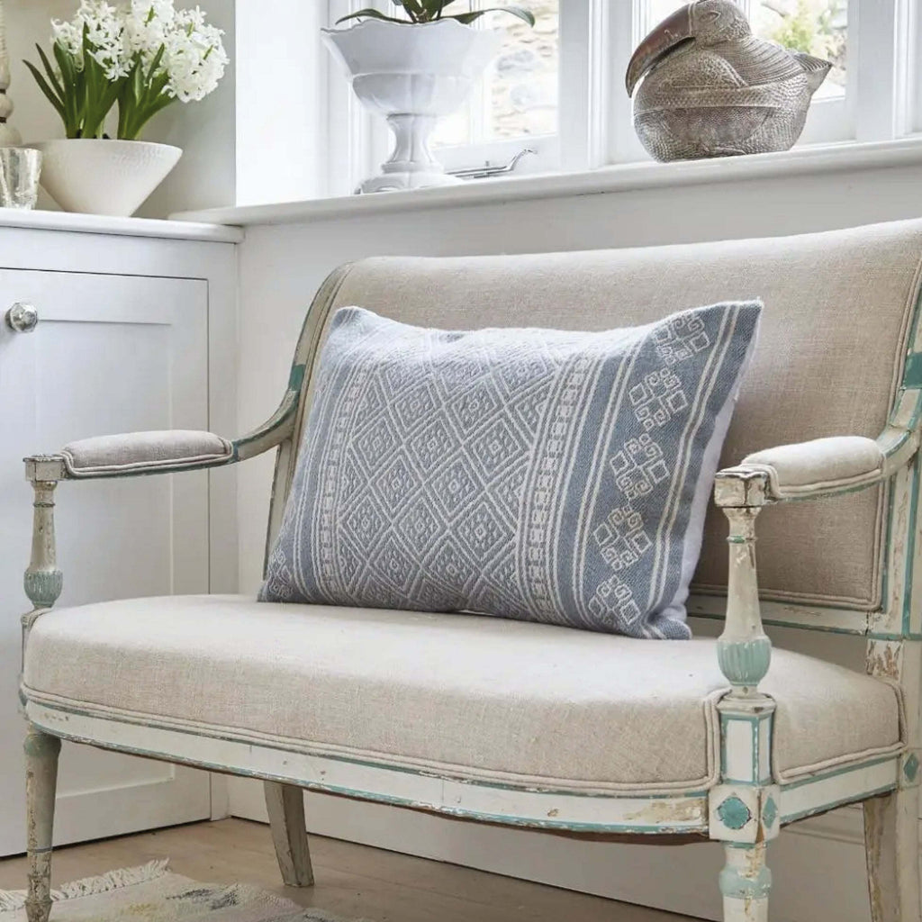 Cornflower Kalkan Cushion with textured jacquard design on a classic chair.