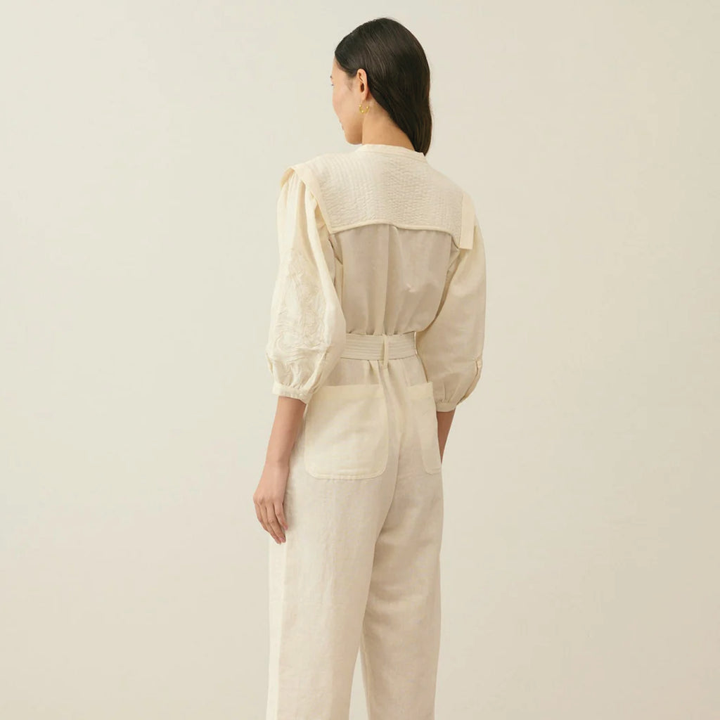 Cream cotton and linen blend jumpsuit with round neckline, lightly quilted breastplate with embroidery details. 
Louise Misha Cream Sylvianna Jumpsuit - Jo And Co Louise Misha Cream Sylvianna Jumpsuit - Louise Misha