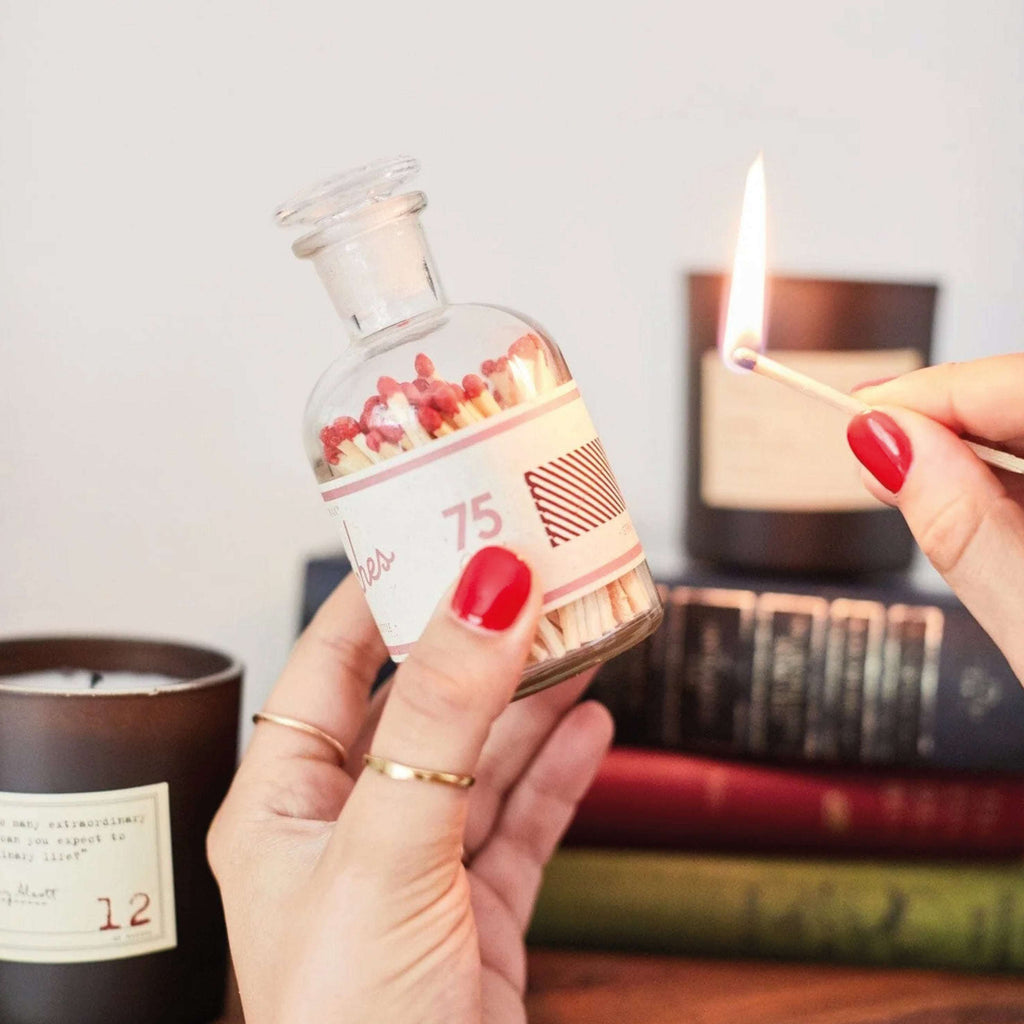 Glass bottle containing 75 red-tipped wooden matches with strike strip.