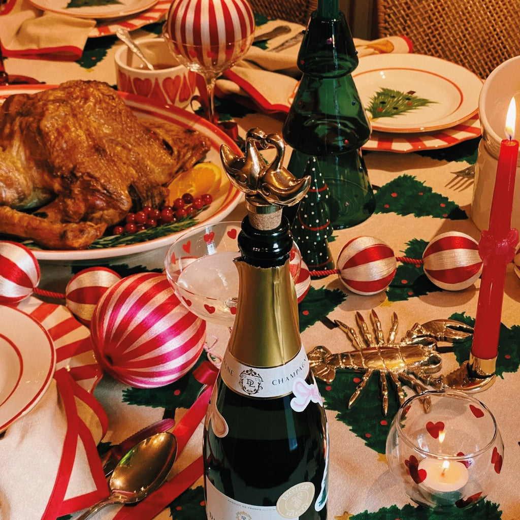 Gold Lovey Dovey Bottle Stopper on festive table setting with Christmas decorations and turkey.