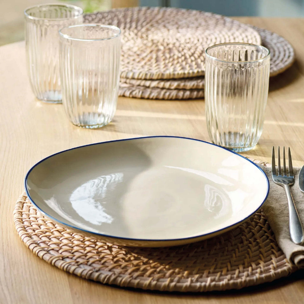 Ink Shipston Pasta Bowl with an organic shape, rustic hand-painted inky blue rim, displayed on a woven mat.