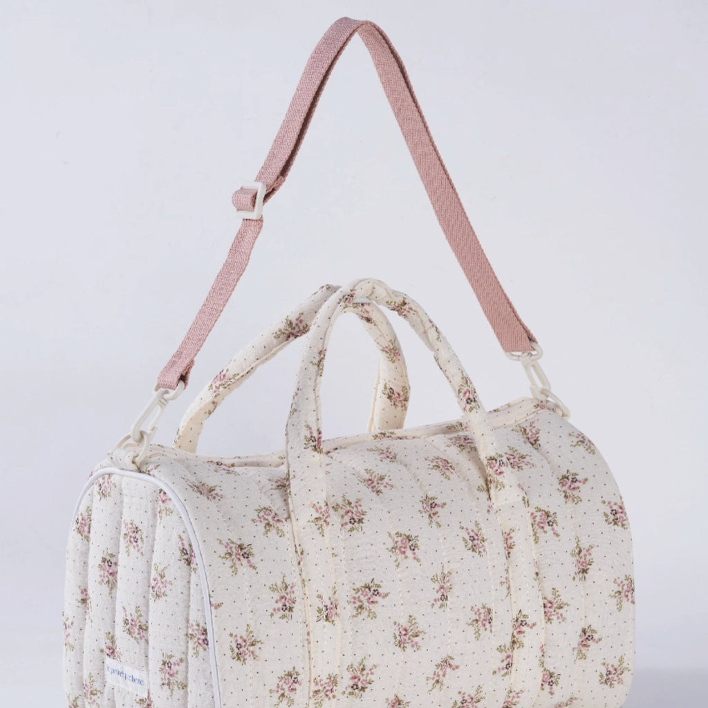 Crepe fabric duffle bag with pink roses print on cream cotton quilted fabric with handles and adjustable pink shoulder strap.
Lilac Floral Duffle Bag - Jo And Co Lilac Floral Duffle Bag