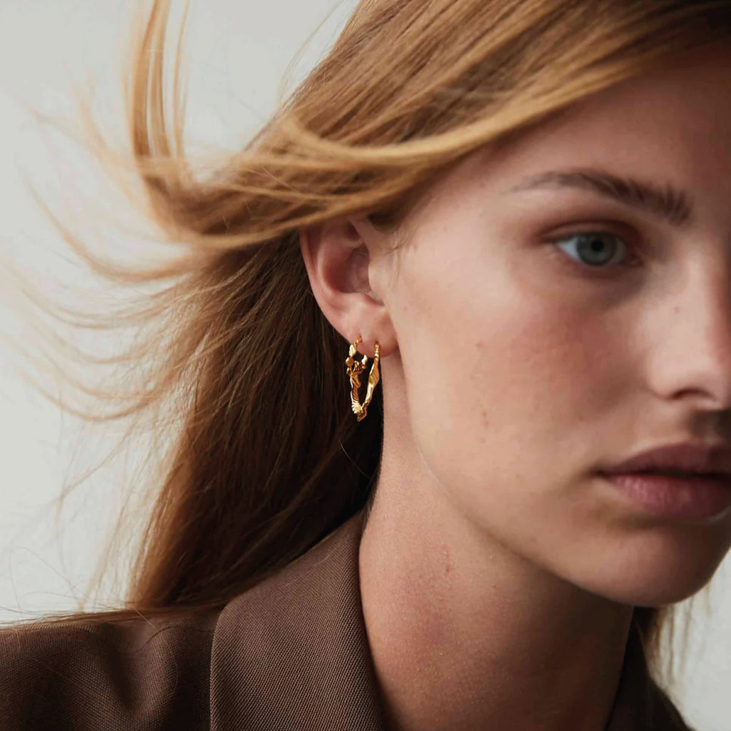 Hultquist Copenhagen Lorelei Grande Hoop Earrings on model with twisted design, 18K gold-plated sterling silver.