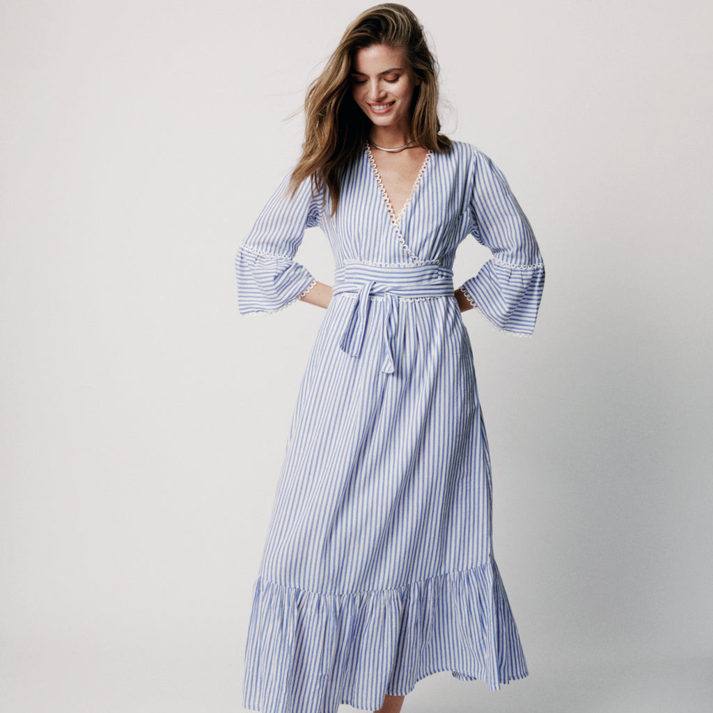 Long blue striped feminine dress with a ruffle detailed crossover v-neck and elastic waist with a flowy pleated panel at bottom.
Moliin Copenhagen Turkish Sea Dulce Dress - Jo And Co Moliin Copenhagen Turkish Sea Dulce Dress - Moliin Copenhagen