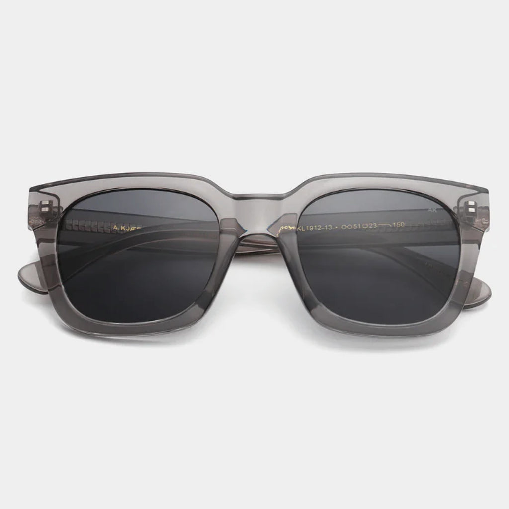 Grey transparent sunglasses with square shape and medium-sized frame.
A.KJAERBEDE Nancy Grey Transparent Sunglasses - Jo And Co A.KJAERBEDE Nancy Grey Transparent Sunglasses - A.KJAERBEDE