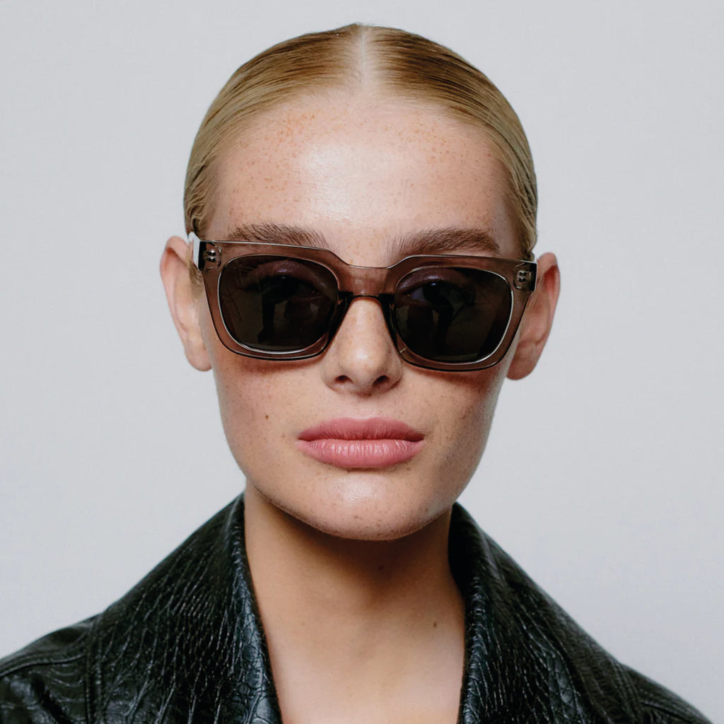 Grey transparent sunglasses with square shape and medium-sized frame.
A.KJAERBEDE Nancy Grey Transparent Sunglasses - Jo And Co A.KJAERBEDE Nancy Grey Transparent Sunglasses - A.KJAERBEDE