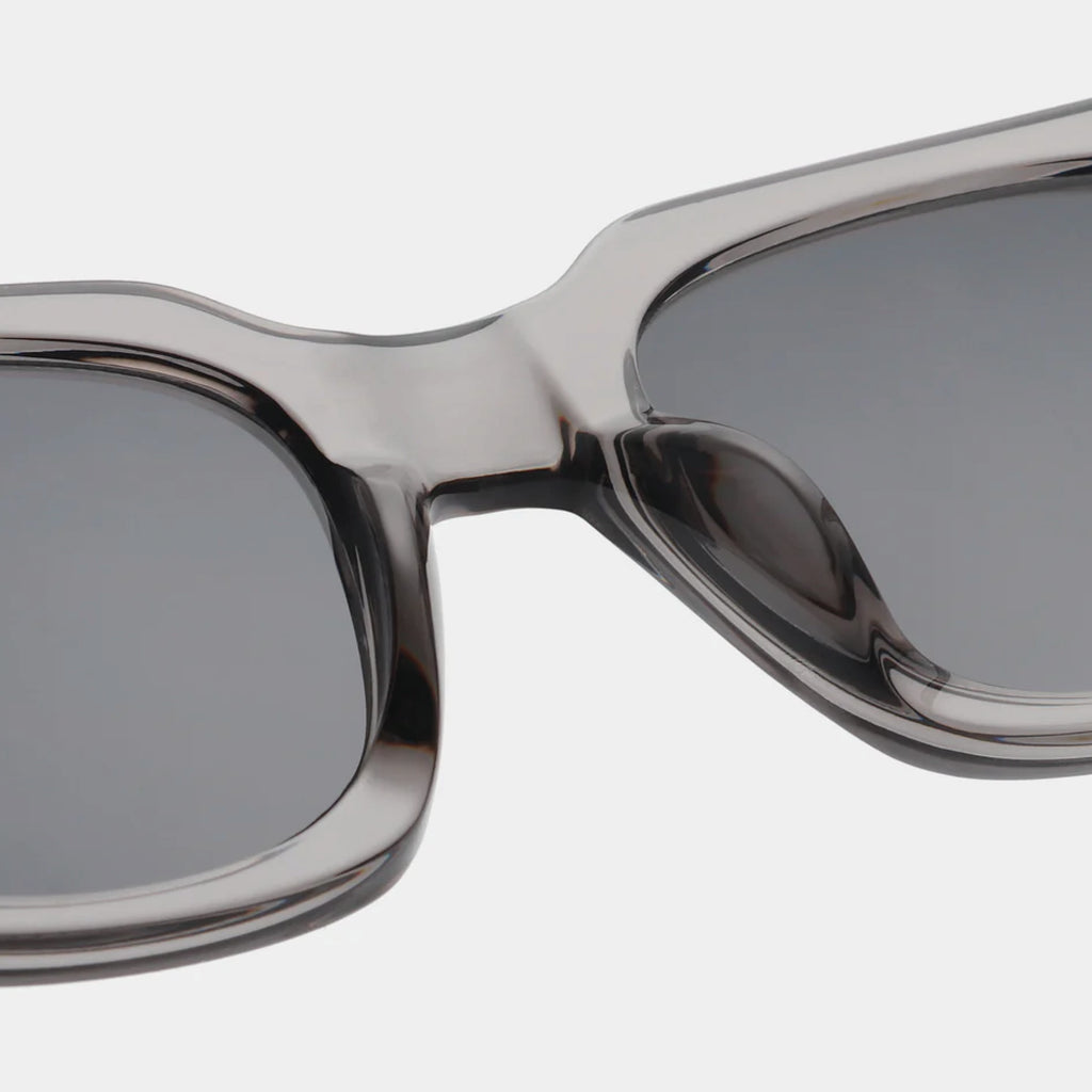 Grey transparent sunglasses with square shape and medium-sized frame.
A.KJAERBEDE Nancy Grey Transparent Sunglasses - Jo And Co A.KJAERBEDE Nancy Grey Transparent Sunglasses - A.KJAERBEDE