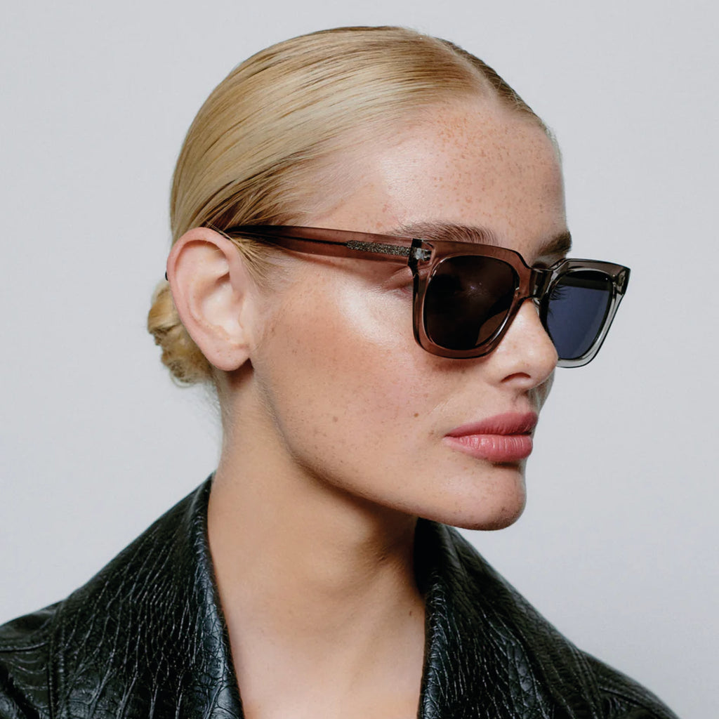 Grey transparent sunglasses with square shape and medium-sized frame.
A.KJAERBEDE Nancy Grey Transparent Sunglasses - Jo And Co A.KJAERBEDE Nancy Grey Transparent Sunglasses - A.KJAERBEDE