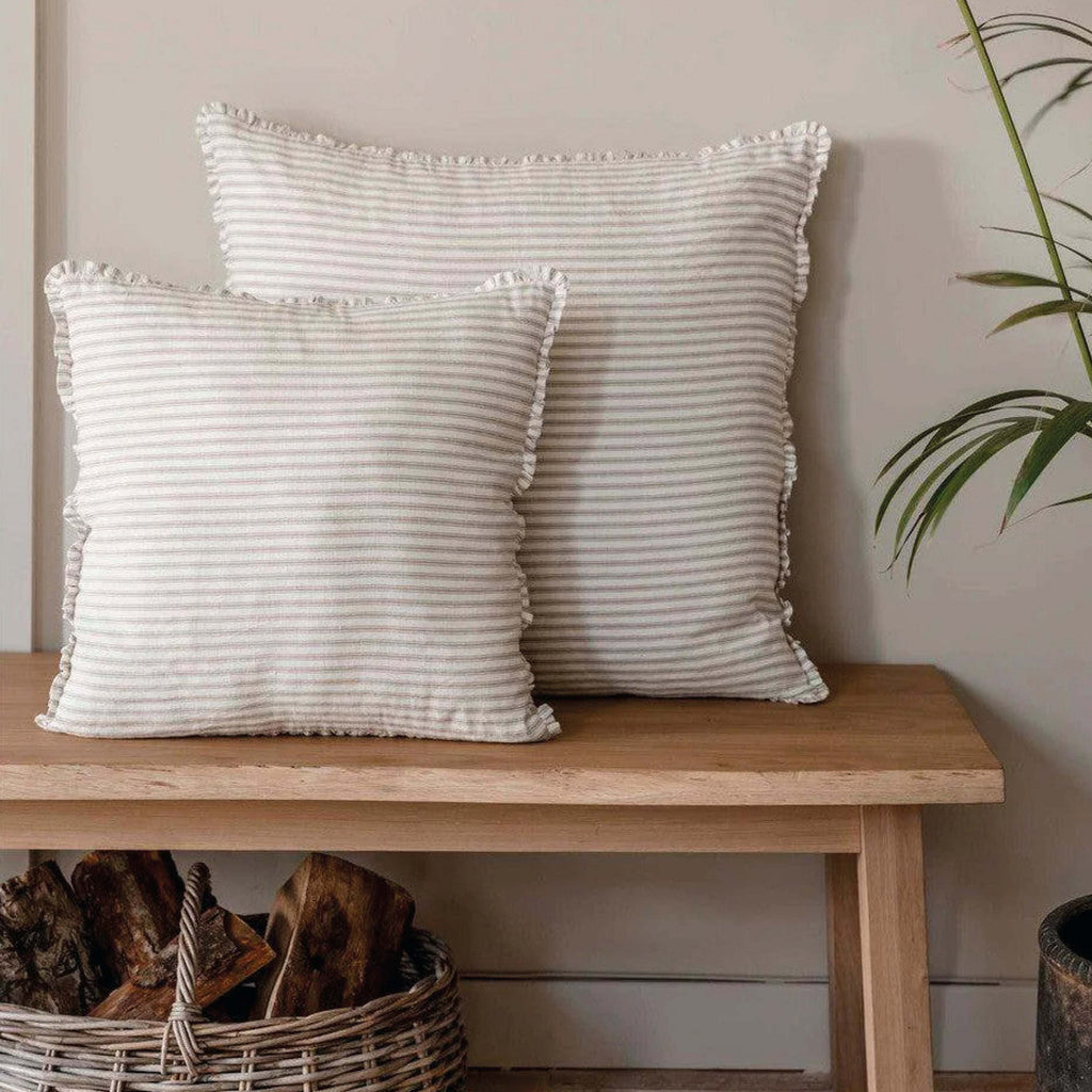 Natural Boxwell Stripe Cushion 60x60cm with yarn dyed stripes and frill, styled on a bench.