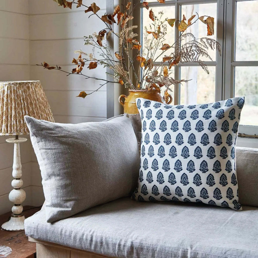 Navy Acorn Canvas Cushion with square acorn print in durable fabric, 45x45 cm, on a cozy sofa.