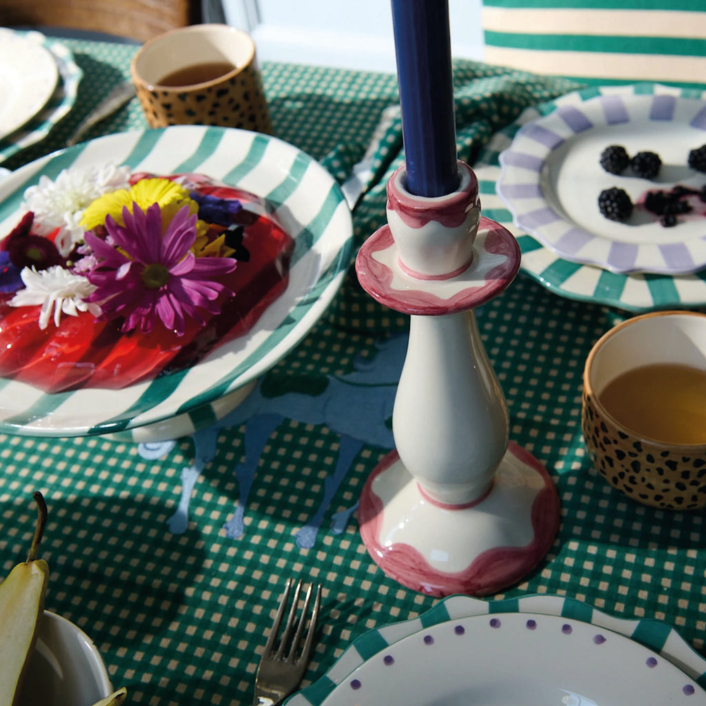 Pink Radiant Candle Holder with ivory-white ceramic design and soft pink details on a patterned dining table.