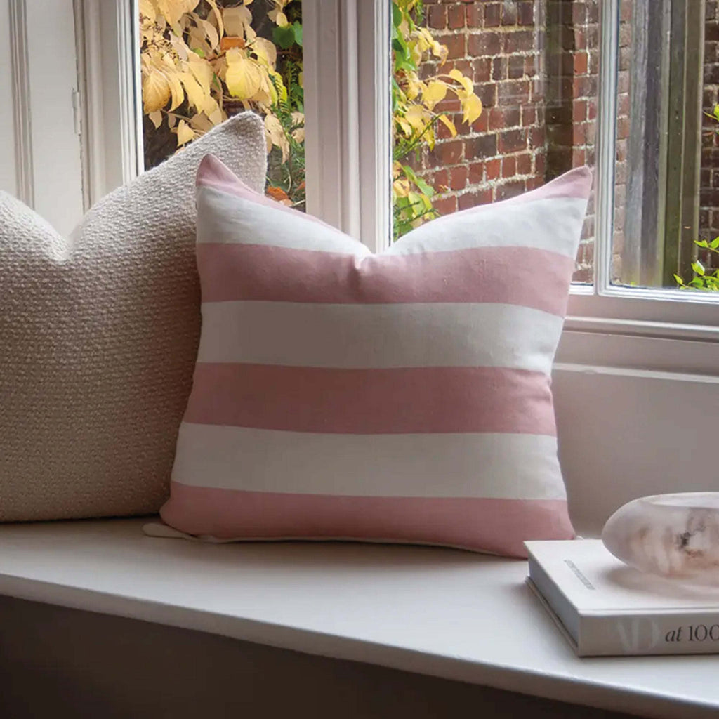 Pink Riviera Striped Linen Cushion on window seat with elegant wide-striped design.