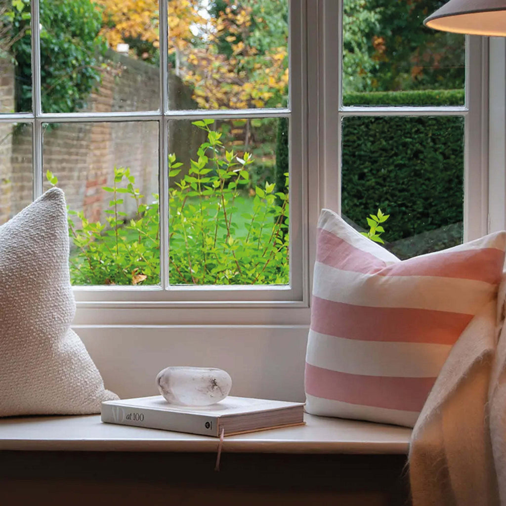 Pink Riviera Striped Linen Cushion on window seat, featuring wide stripes and crafted from linen-cotton blend for a luxurious touch.