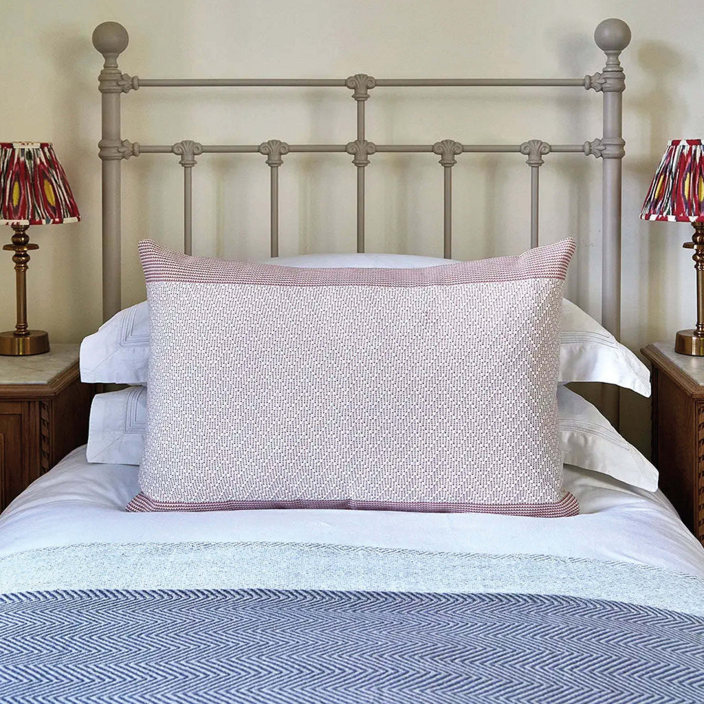 Rose Pink Chevron Cushion with raised embroidery on a white bed linen, 40 x 60 cm.