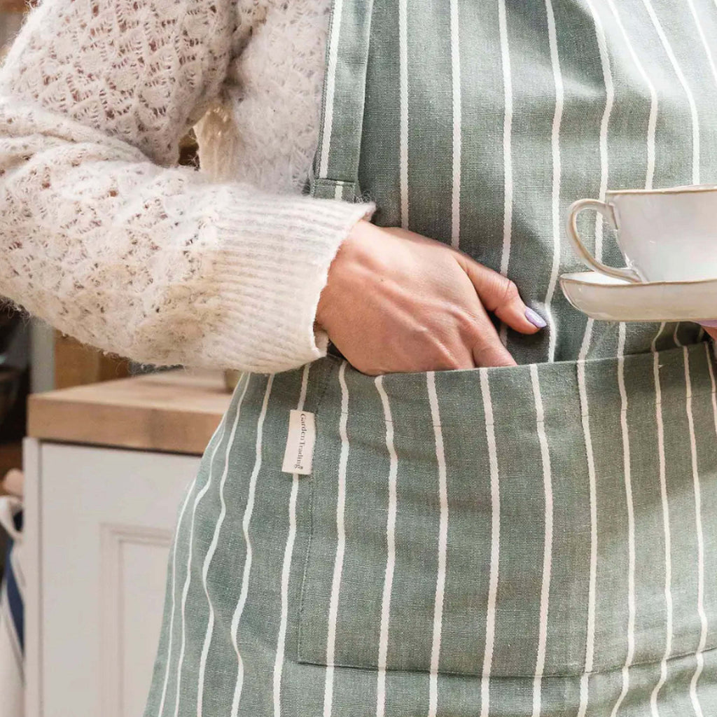 Rosemary Bampton Apron with white stripes and front pocket in a kitchen setting.