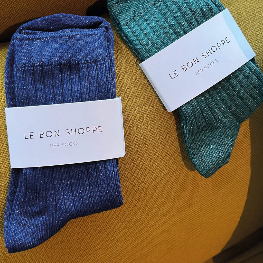 Le Bon Shoppe Sapphire Glitter Her Socks in blue and green, displayed on a yellow surface.