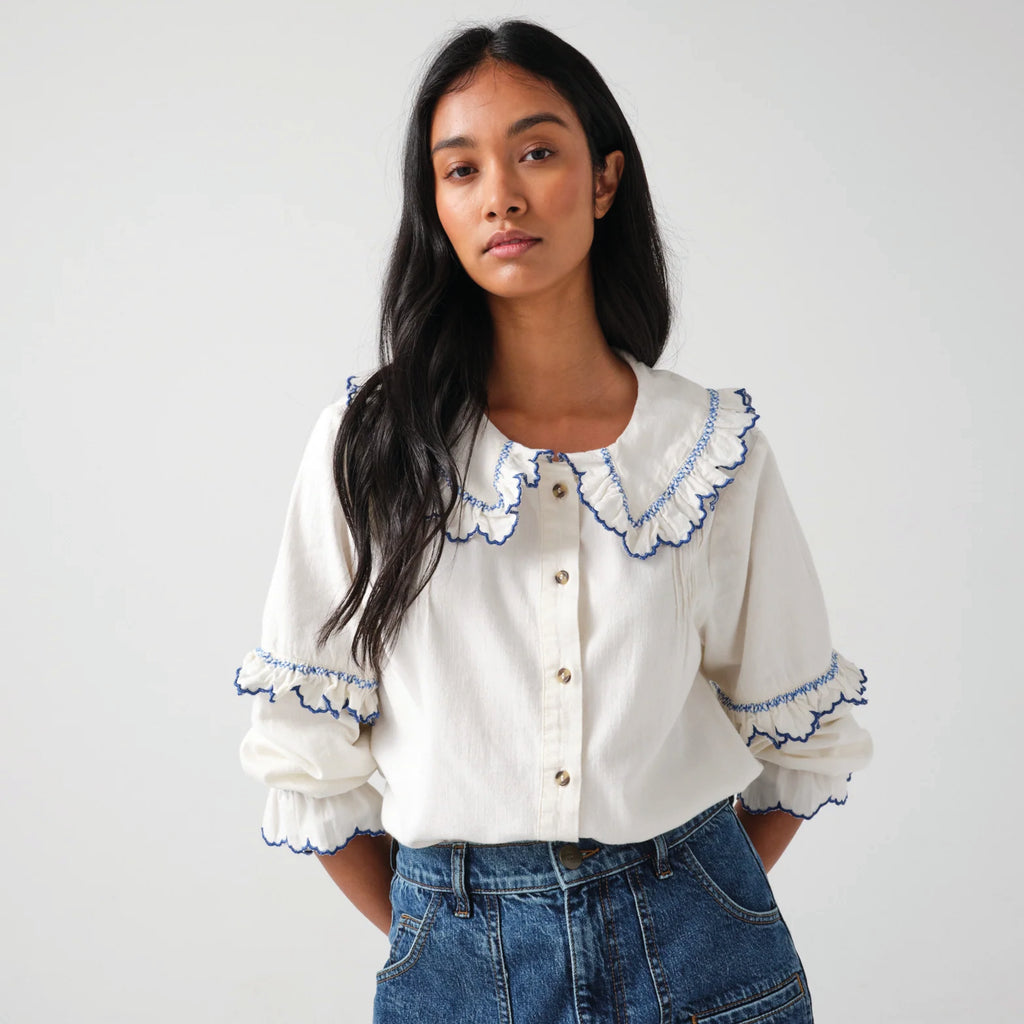 White cotton blouse with blue embroidered frill collar and sleeves.
Seventy + Mochi Ecru & Electric Blue Phoebe Blouse - Jo And Co Seventy + Mochi Ecru & Electric Blue Phoebe Blouse - Seventy + Mochi