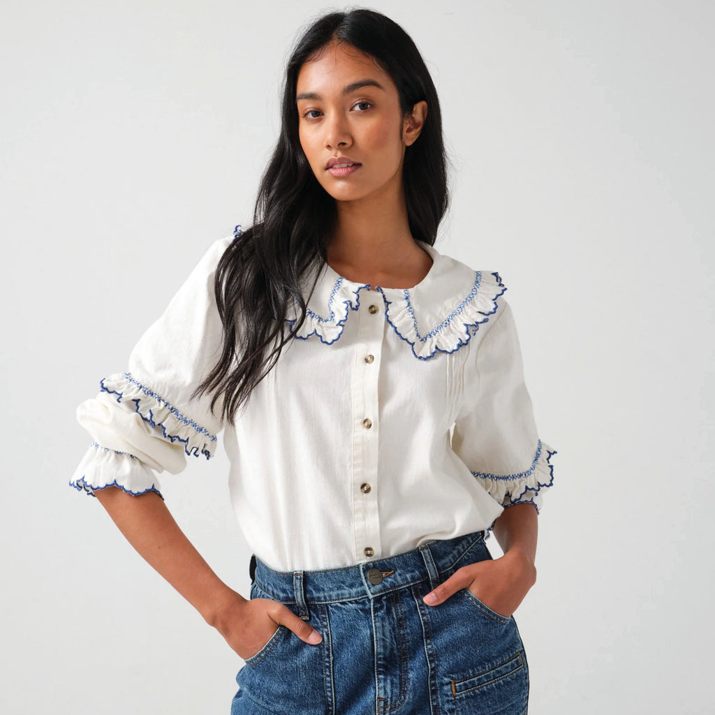 White cotton blouse with blue embroidered frill collar and sleeves.
Seventy + Mochi Ecru & Electric Blue Phoebe Blouse - Jo And Co Seventy + Mochi Ecru & Electric Blue Phoebe Blouse - Seventy + Mochi