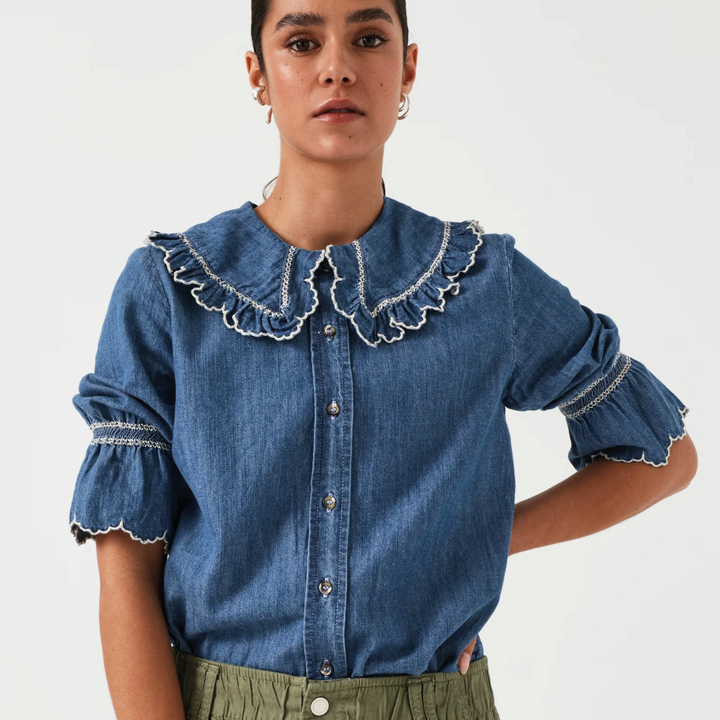 Indigo denim blue blouse with embroidered frill collar and cuffs and feminine cropped sleeves.
Seventy + Mochi Indigo Denim Daisy Blouse - Jo And Co Seventy + Mochi Indigo Denim Daisy Blouse - Seventy + Mochi