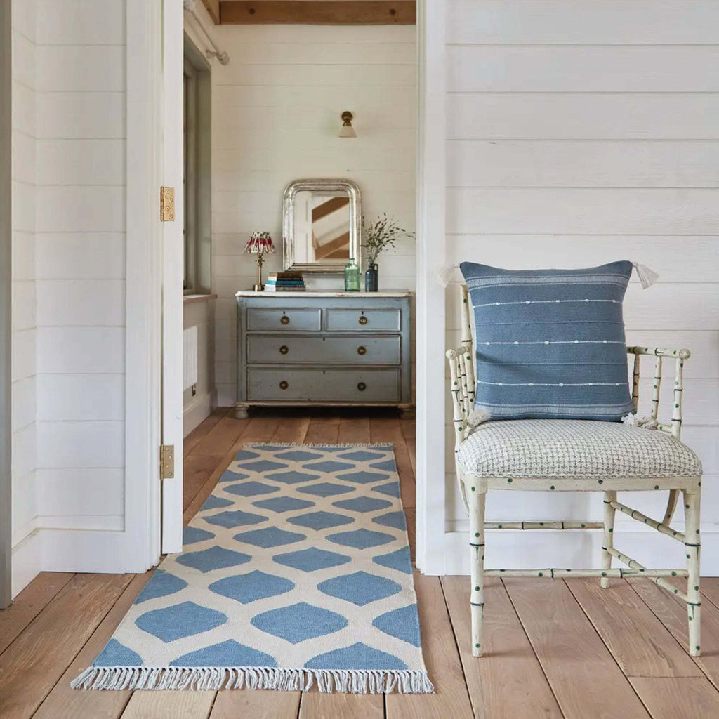 Sky Blue Tassel Cushion with slub yarn weave and striped design on chair.