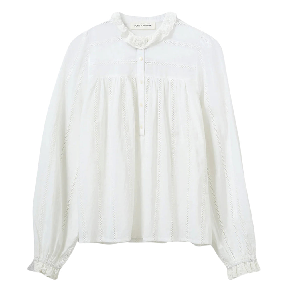 White blouse with frilled collar and pointelle details, half-buttoned front closure and slightly puffed sleeves.
Sofie Schnoor Snow White Asoria Blouse - Jo And Co Sofie Schnoor Snow White Asoria Blouse - Sofie Schnoor